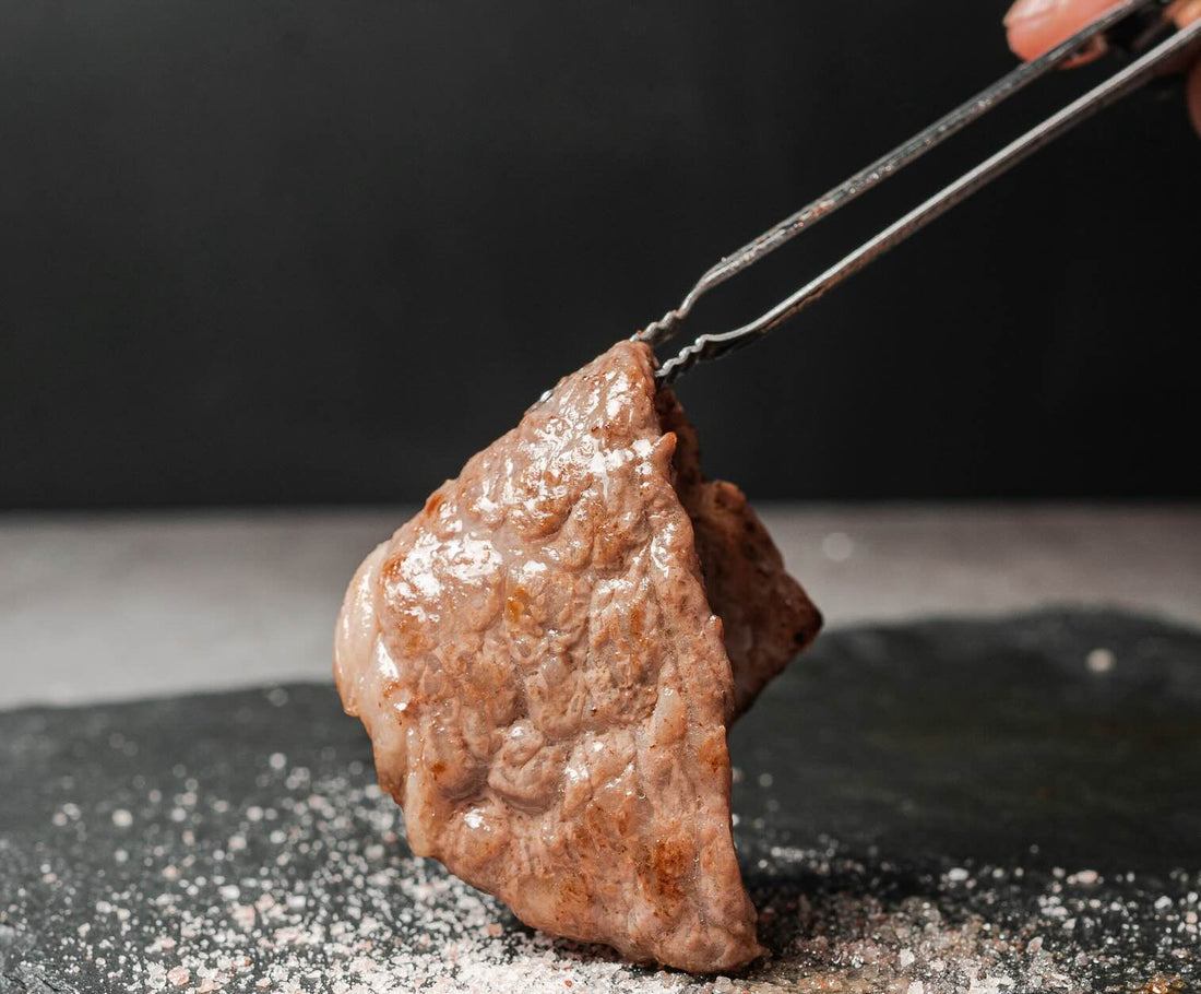 Seared wagyu steak served with garnish and dipping sauce.