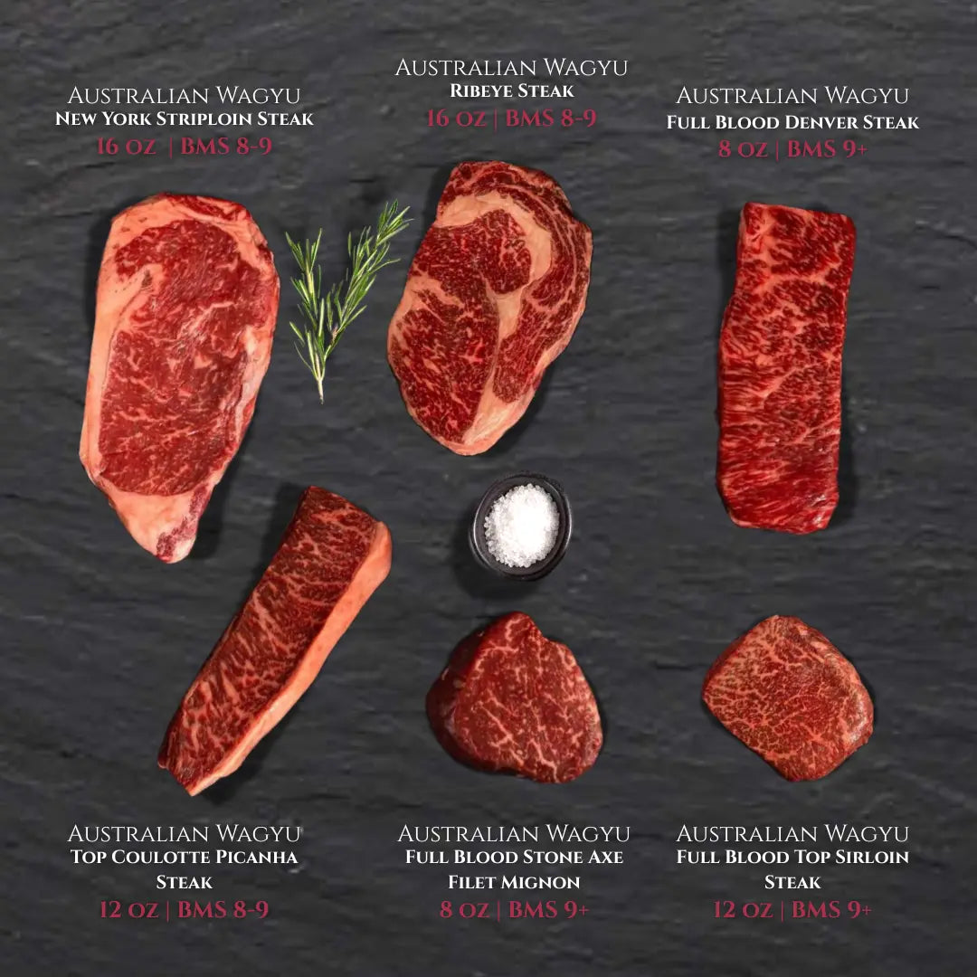 A combination of 6 Australian wagyu steaks on a black slate board with salt.