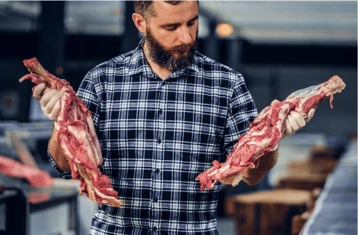 Man holding cuts of Wagyu beef.