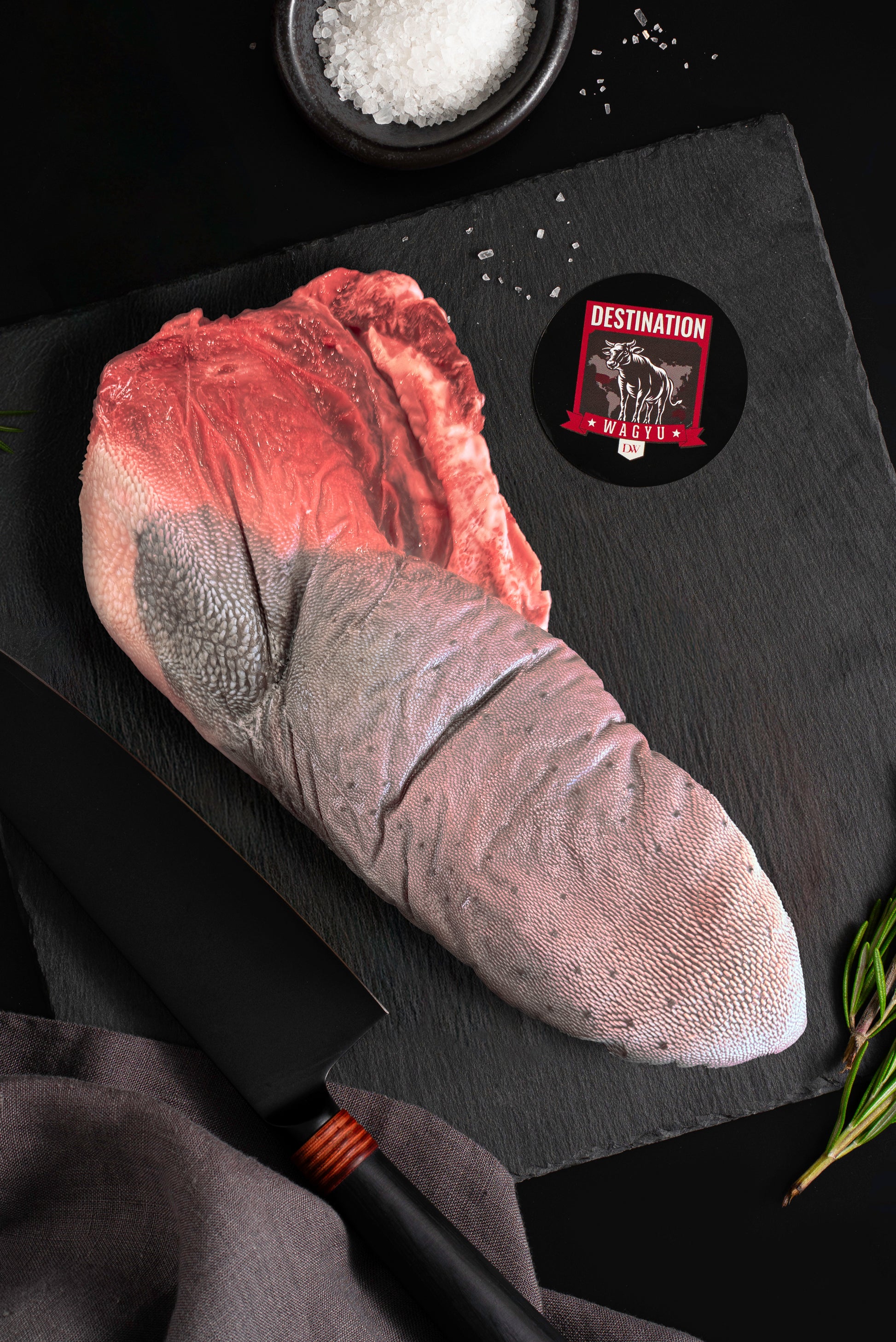 An Australian wagyu beef tongue uncooked on a black board