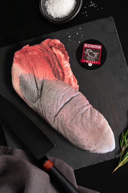 An Australian wagyu beef tongue uncooked on a black board