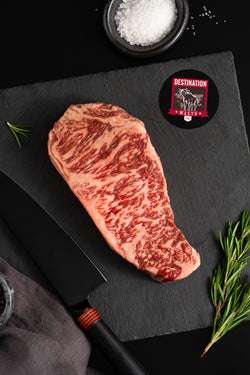 An Australian wagyu full blood striploin steak on a black board 