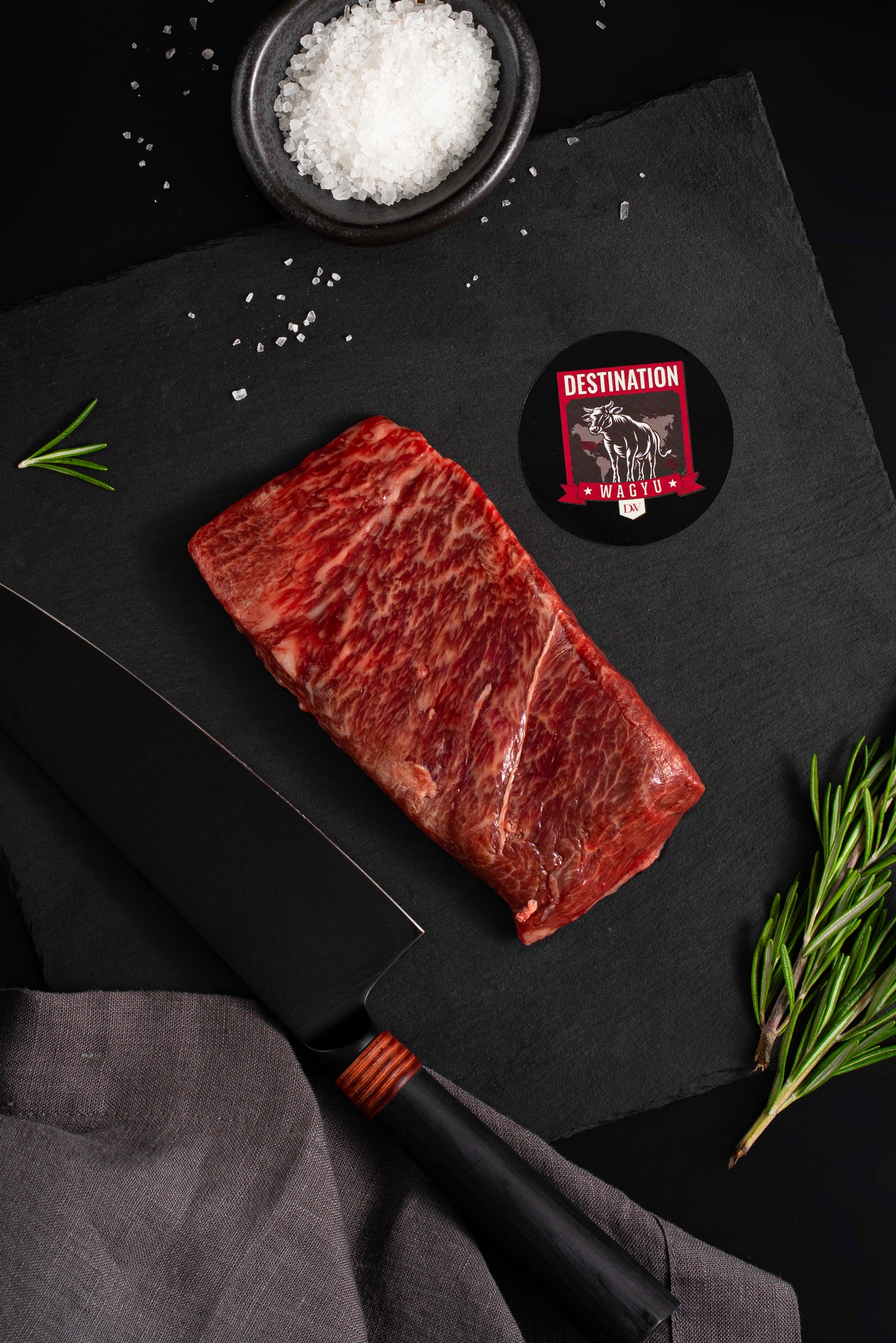 An Australian wagyu full blood flat iron steak on a black slate board with knife and salt 