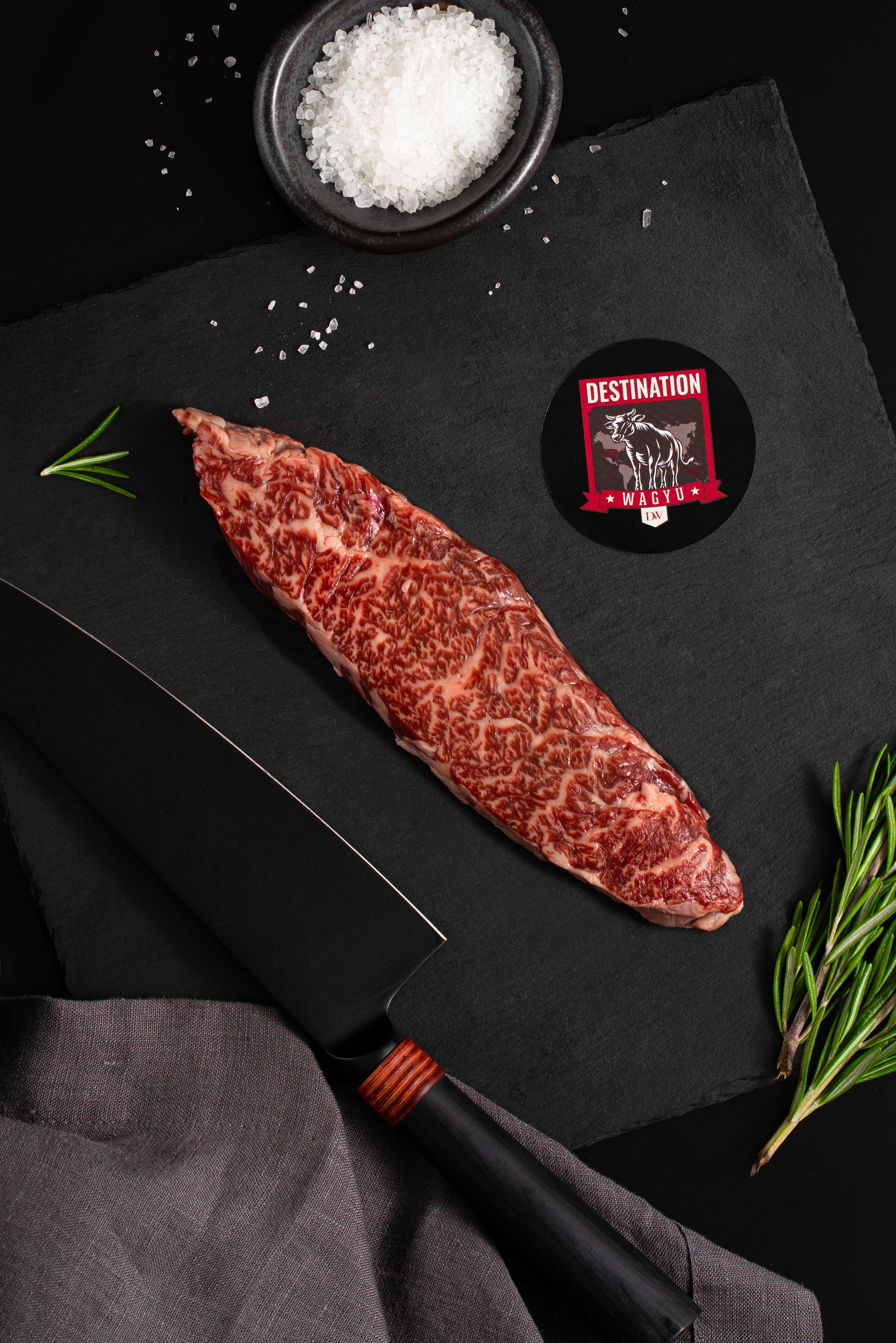 a 6oz japanese a5 wagyu flap meat steak on a black board with salt and knife 