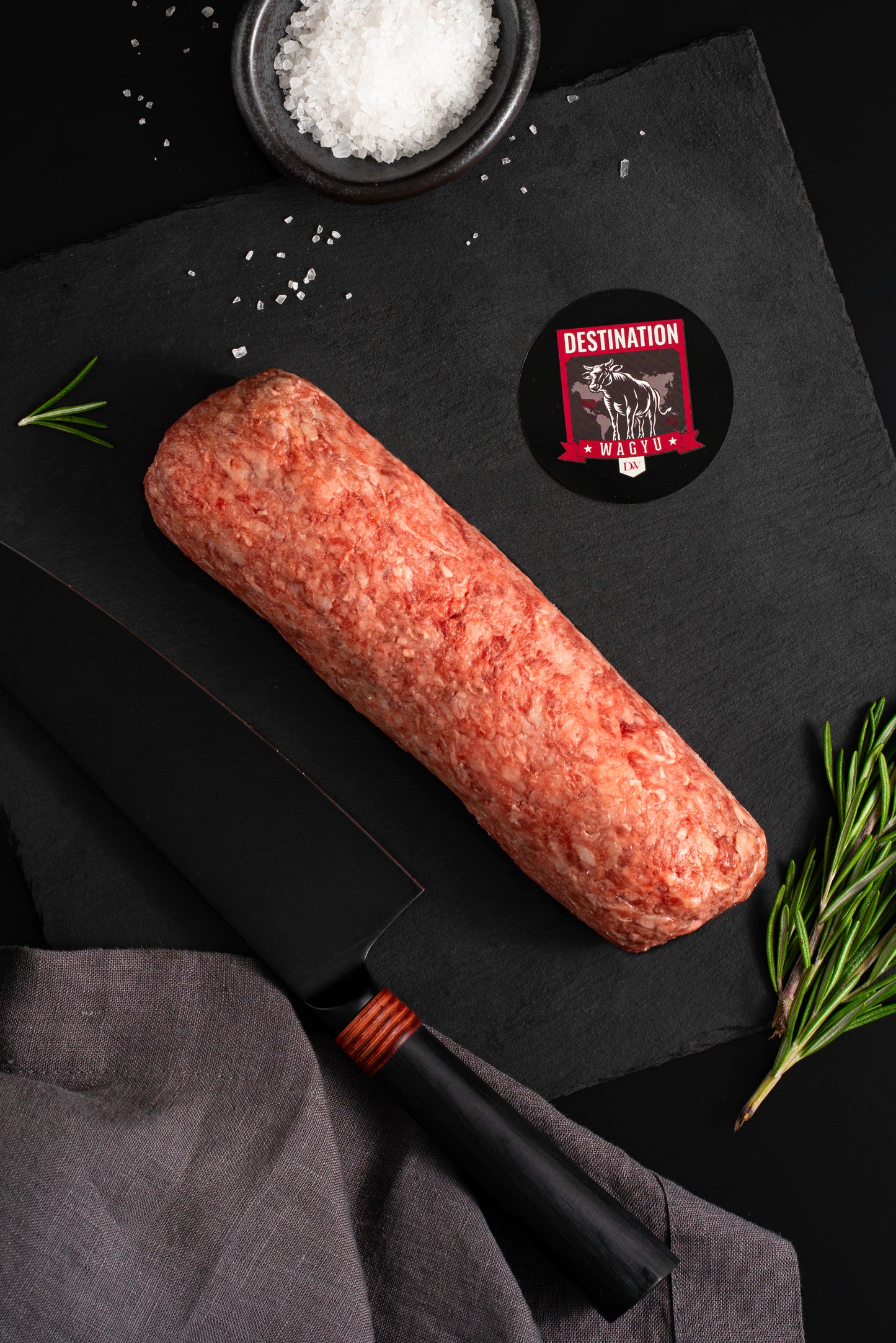 Japanese a5 wagyu ground beef in 16oz size on a slate black board with knife and sa