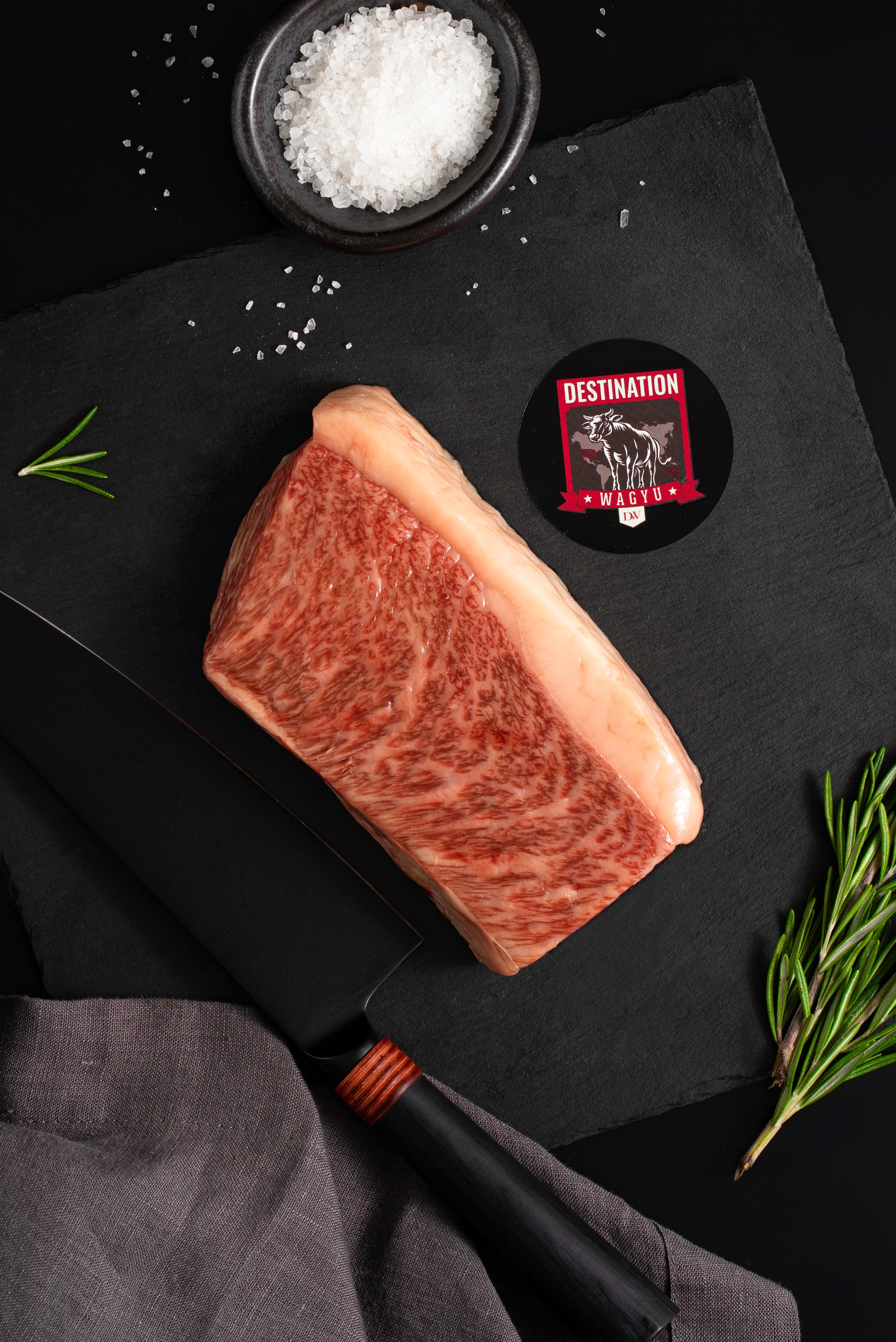 a Japanese a5 wagyu picanha steak in 12oz size on a black board with salt and knife 