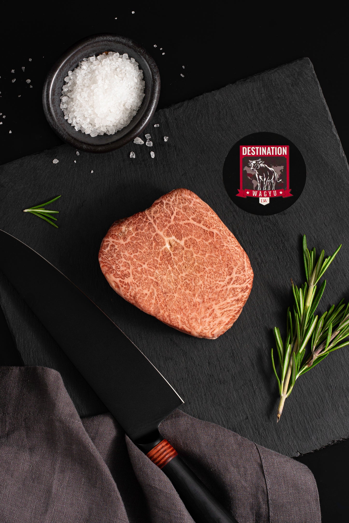 an 8oz Kobe Wine Japanese A5 wagyu filet mignon steak on a black board with salt and knife