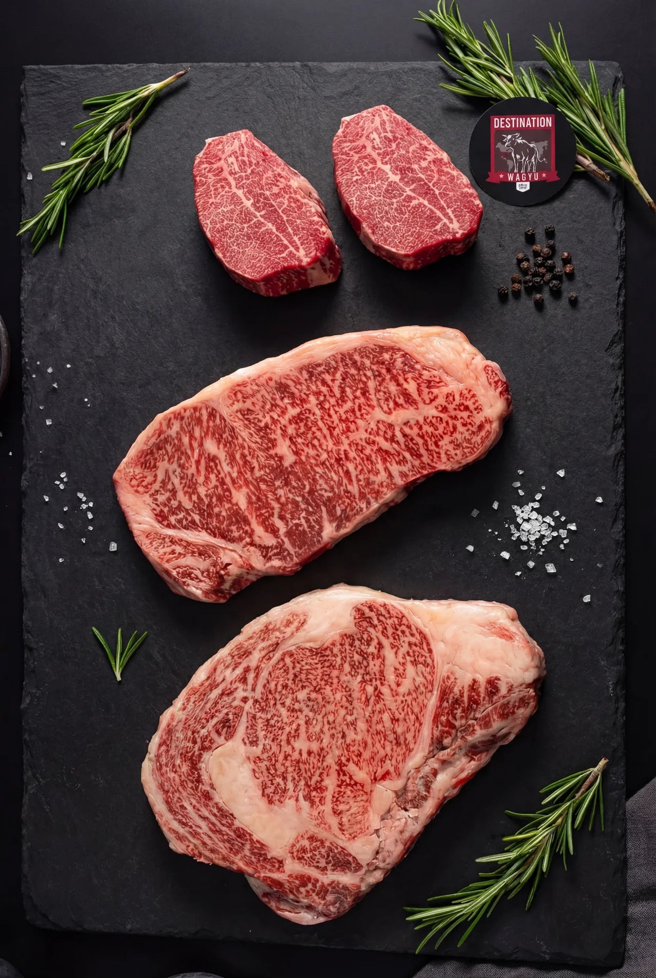 Japanese A5 Miyazaki wagyu beef collection with ribeye steak, striploin steak, and filet mignon on slate board - premium marbled beef